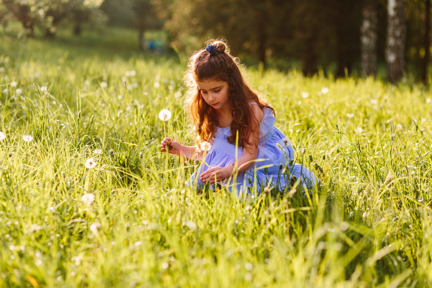 Meisje met hooikoorts zit in een grasveld met bloemen en pollen